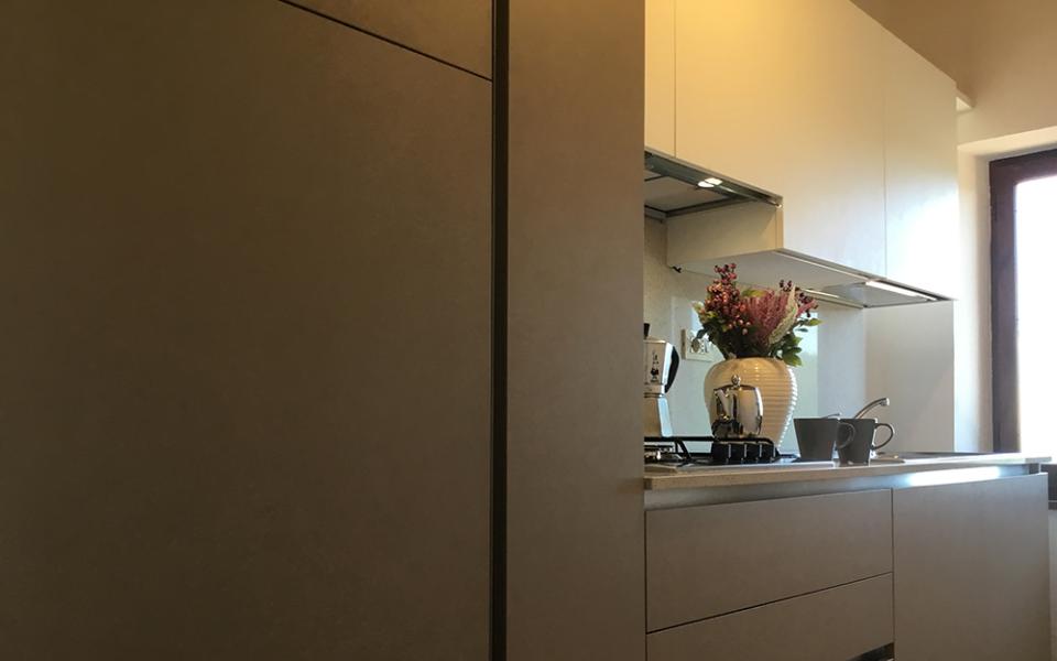 Cucina moderna con fiori, moka e tazze su un piano di lavoro.