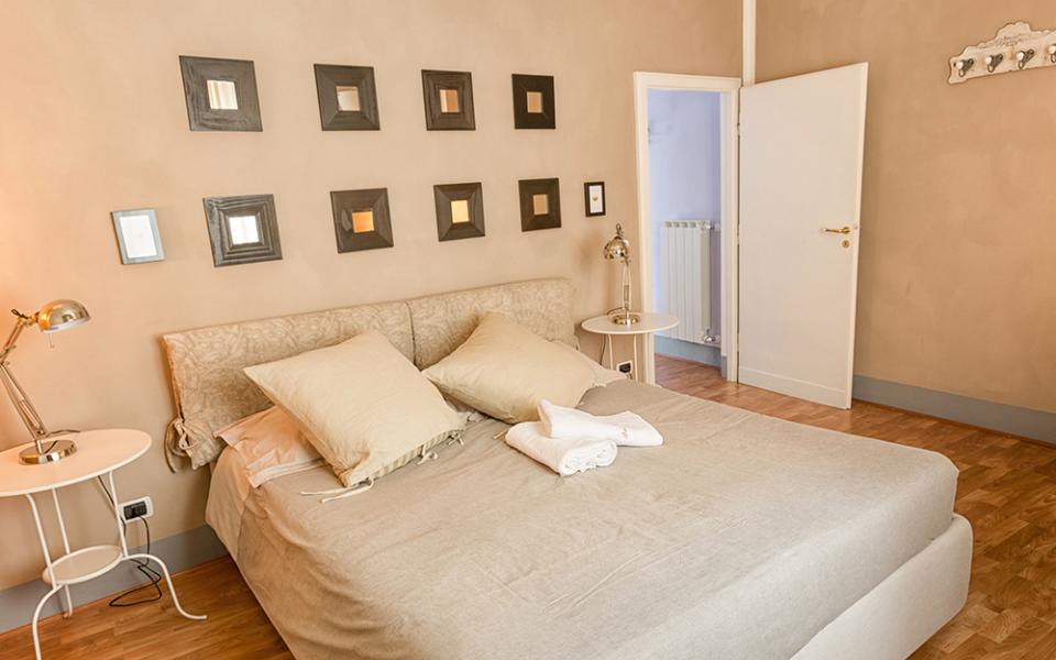 Camera da letto accogliente con letto matrimoniale, decorazioni a parete e lampade da comodino.